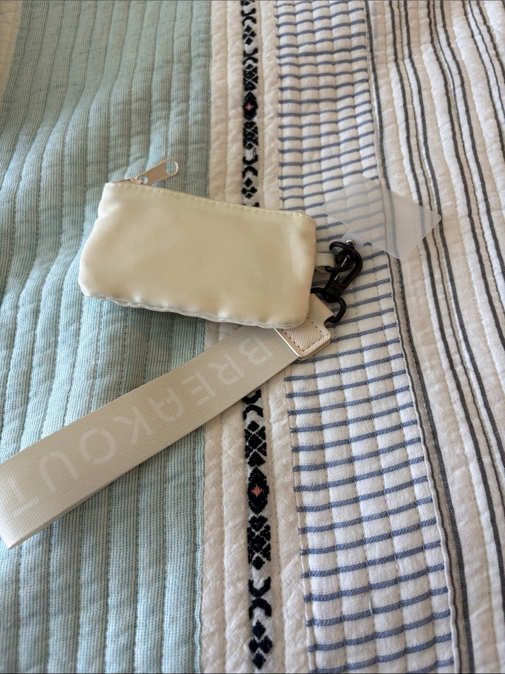 Ivory Satin Wristlet Pouch with Wide Logo Strap and cell phone attachment